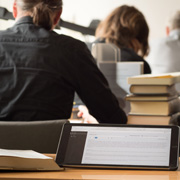 Blick auf Studierende mit Bücherstapeln